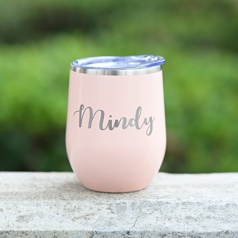 Puede incluir: Un vaso de vino de acero inoxidable rosa con una tapa azul y el nombre "Mindy" grabado en el lateral.