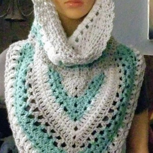 May include: A white and teal crocheted cowl with a hood. The cowl is made with a lacy stitch pattern.