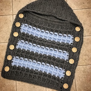 May include: Gray and light blue crocheted baby swaddle with a hood and wooden buttons. The buttons have the text "Handmade with love" on them.