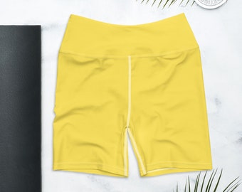 Puede incluir: Shorts deportivos amarillos con una costura blanca en el centro de las piernas.