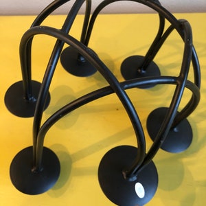 Puede incluir: Un portavelas de metal negro con un dise&ntilde;o &uacute;nico e entrelazado. El portavelas presenta seis bases circulares y varillas met&aacute;licas curvas e intersecantes. Dise&ntilde;ado para m&uacute;ltiples velas, es adecuado para la decoraci&oacute;n del hogar.