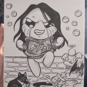 May include: Black and white ink drawing of a cartoon character with long black hair, wearing a hoodie with Japanese text. The character is crying and jumping over a puddle. A cat and angel are also in the drawing.
