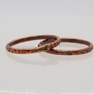 May include: Two thin copper rings with a textured, hammered finish. The rings are stacked on top of each other.