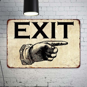 May include: A vintage-style metal sign with a distressed background. The sign features the word "EXIT" in black lettering and a black and white illustration of a pointing hand.