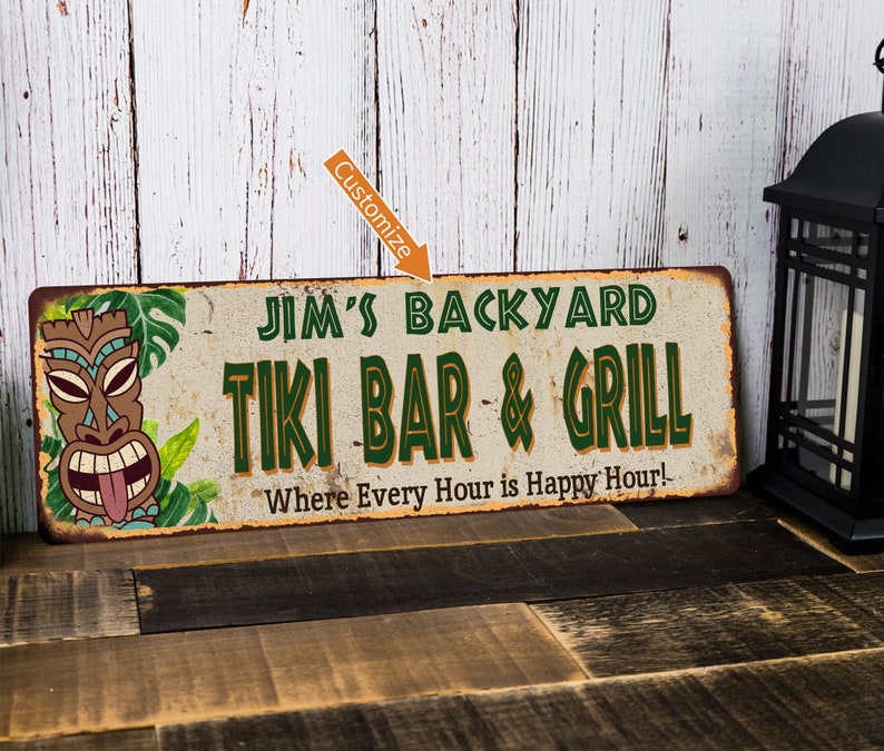 May include: A rustic metal sign with a tiki head and tropical leaves. The sign reads "Jim's Backyard Tiki Bar & Grill" and "Where Every Hour is Happy Hour!"