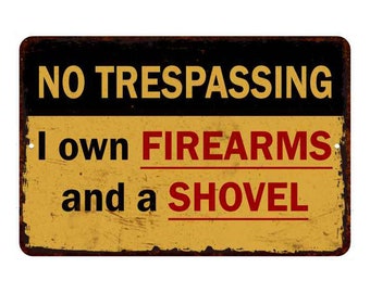 May include: A yellow and black warning sign with the text "NO TRESPASSING I own FIREARMS and a SHOVEL" in red and black lettering.