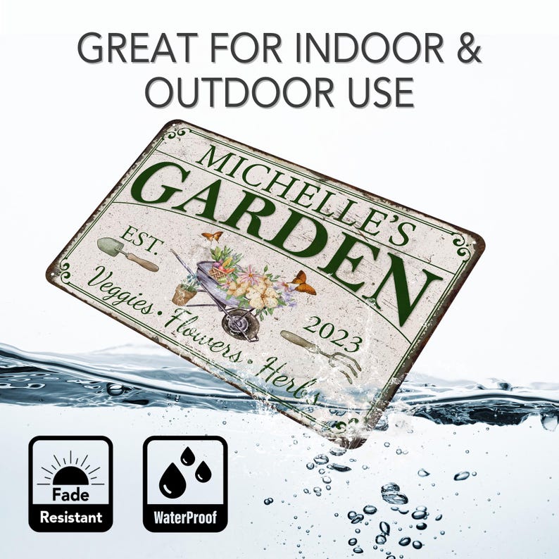 Peut inclure: Une plaque en m&eacute;tal blanc avec du texte vert qui dit "Michelle's Garden" avec une brouette pleine de fleurs et le texte "Est. 2023 Veggies Flowers Herbs". La plaque est partiellement immerg&eacute;e dans l'eau, avec une ic&ocirc;ne de soleil &eacute;tiquet&eacute;e "Fade Resistant" et une ic&ocirc;ne de goutte d'eau &eacute;tiquet&eacute;e "Waterproof" en dessous.