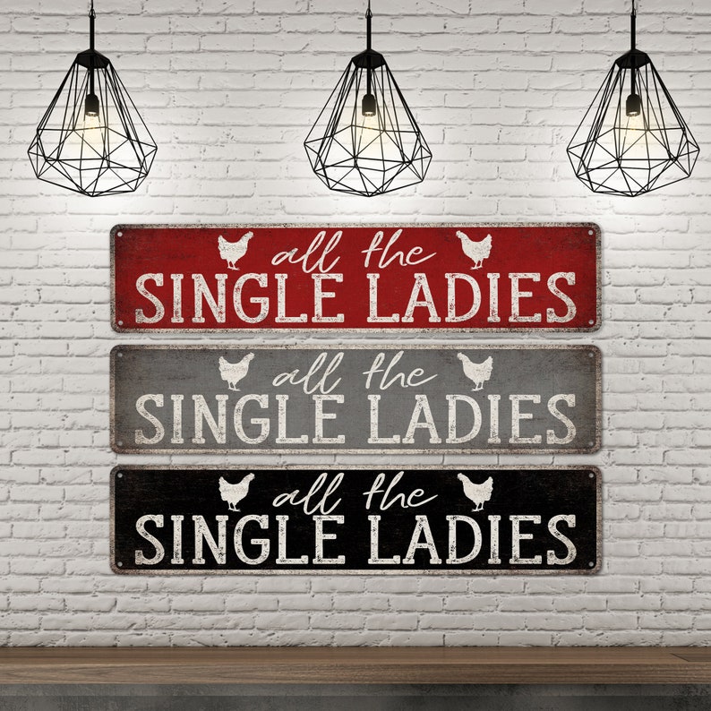 Pu&ograve; includere: Tre cartelli in legno rustico con una finitura usurata. Ogni cartello presenta una silhouette di pollo bianca e il testo "all the single ladies" in lettere bianche.