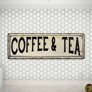 May include: A vintage-style metal sign with a white background and black lettering that reads "COFFEE & TEA".