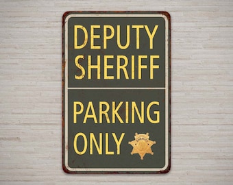 May include: A rusty green metal sign with the text "DEPUTY SHERIFF PARKING ONLY" in yellow letters. A gold sheriff's star is in the bottom right corner.