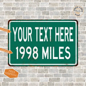 May include: A green and white metal sign with the text "YOUR TEXT HERE" and "1998 MILES" in white. The sign has a distressed, rusty look.