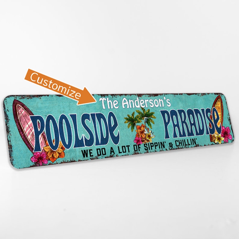 Pode incluir: Uma placa de metal azul turquesa e branco com o texto "Poolside Paradise" em letras azuis. A placa tamb&eacute;m apresenta uma palmeira, flores e uma prancha de surf. O texto "The Anderson's" est&aacute; acima do texto principal e o texto "We do a lot of sippin' & chillin'" est&aacute; abaixo do texto principal.