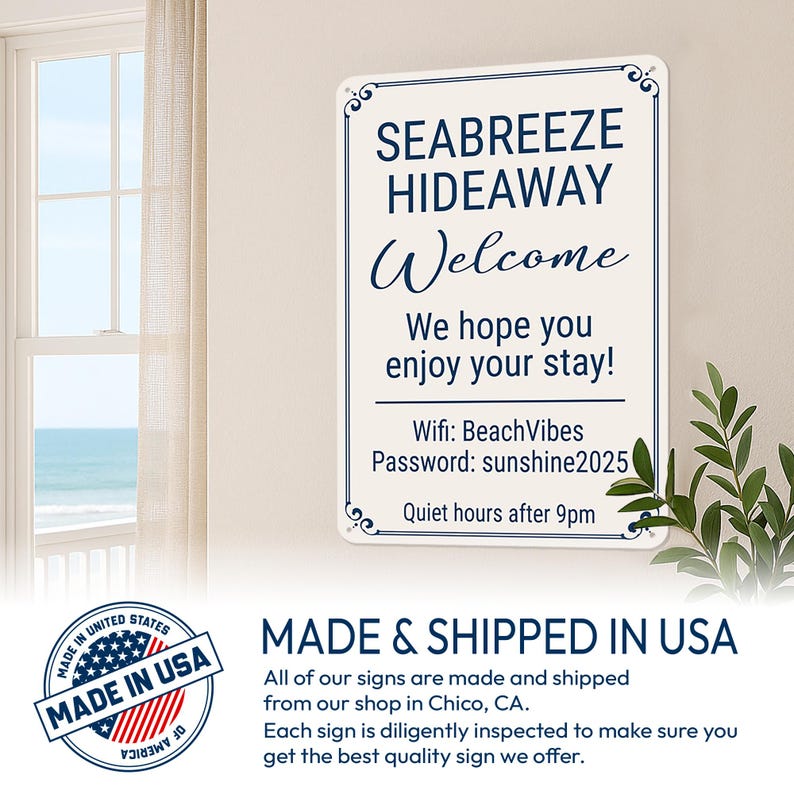 Op de afbeelding: Een rechthoekig wit metalen bord met een marineblauwe rand en de tekst "SEABREEZE HIDEAWAY Welcome". Het bord bevat wifi-informatie en een welkomstboodschap. Het bord hangt aan een muur bij een raam.