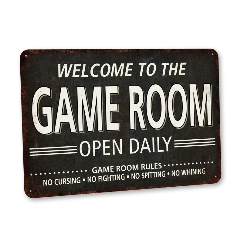 May include: A black and white metal sign with the text "Welcome to the Game Room Open Daily" and the rules "Game Room Rules: No Cursing, No Fighting, No Spitting, No Whining".