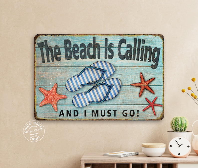 May include: A blue and white wooden sign with the text "The Beach Is Calling And I Must Go!"  The sign features two pairs of flip flops, two red starfish, and a blue and white wooden background.