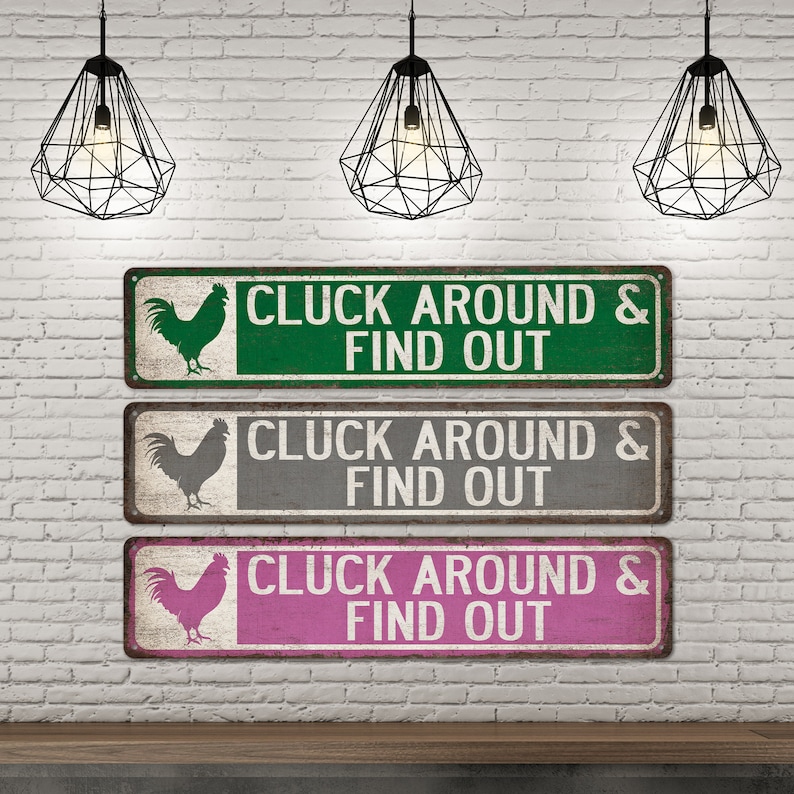 K&ouml;nnte beinhalten: Drei rustikale Metallschildchen mit einer Hahnensilhouette und dem Text "CLUCK AROUND & FIND OUT" in wei&szlig;en Buchstaben. Die Schilder sind gr&uuml;n, grau und rosa.
