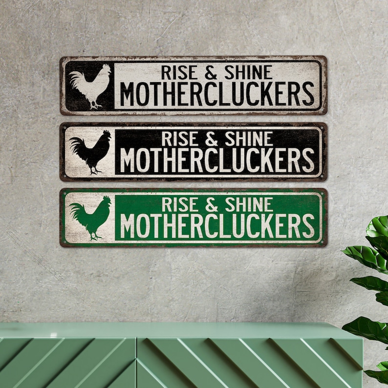 May include: Three metal signs featuring a rooster silhouette and the text "Rise & Shine Mothercluckers". The signs are in black and white, black and white with a distressed look, and green and white.
