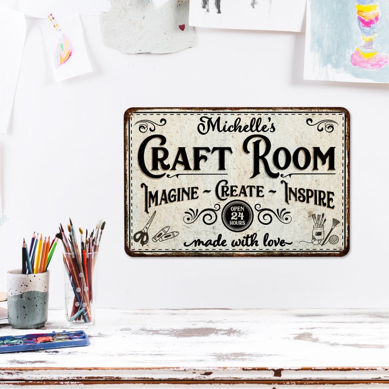 May include: A white metal sign with a distressed look, featuring the text "Michelle's Craft Room Imagine - Create - Inspire" with a clock that says "Open 24 Hours" and the text "made with love".