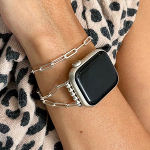May include: A silver Apple Watch with a silver chain link band. The watch is on a person's wrist.