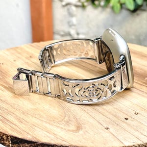 Pulseira Fitbit Versa 4 com estampa floral prateada, pulseira de metal com pingente, pulseira rígida Sense 2 para mulheres.