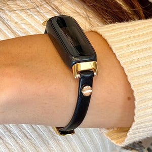 Slim Fitbit Luxe band zwart leren armband met gouden accenten, stijlvolle damesband