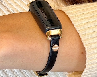 Smukły pasek Fitbit Luxe Band z czarnej skóry ze złotymi akcentami, elegancki pasek damski