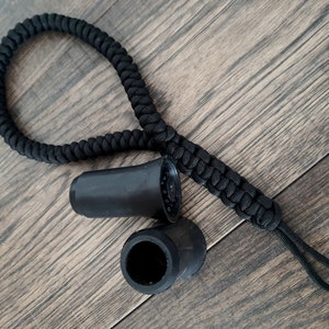 Pu&ograve; includere: Due punte per bastone da passeggio in gomma nera e un cinturino in paracord nero.