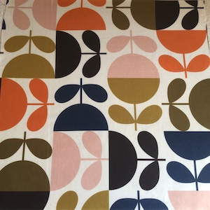 May include: A white fabric with a repeating pattern of stylised flowers in shades of pink, orange, brown, green, black, and navy blue.