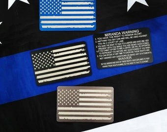 Metal Miranda Card with torn American Flag on the back.