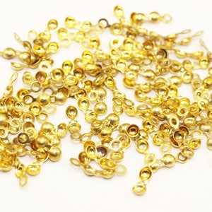 Peut inclure: Un tas de capsules de perles en métal de couleur dorée avec une petite boucle de chaque côté. Les capsules de perles sont conçues pour être utilisées pour la fabrication de bijoux.