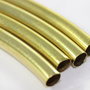 Puede incluir: Cuatro piezas de tuber&iacute;a met&aacute;lica redonda, brillante y de color dorado. La tuber&iacute;a est&aacute; ligeramente curvada y los extremos est&aacute;n cortados en &aacute;ngulo.