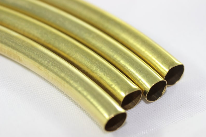 Puede incluir: Cuatro piezas de tuber&iacute;a met&aacute;lica redonda, brillante y de color dorado. La tuber&iacute;a est&aacute; ligeramente curvada y los extremos est&aacute;n cortados en &aacute;ngulo.