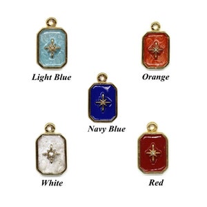 Puede incluir: Cinco dijes de oro con un diseño de estrella en diferentes colores: azul claro, naranja, azul marino, blanco y rojo.