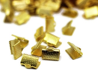 May include: Gold metal clasps for jewelry making. The clasps are small and have a textured surface.