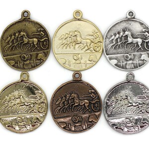 May include: Six round metal charms with a design of a chariot pulled by four horses. The charms are in different finishes: gold, silver, bronze, and antique silver.