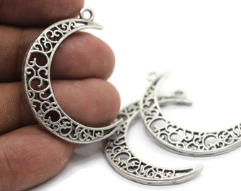 May include: Silver filigree crescent moon charms with a decorative design. These charms are perfect for jewelry making, scrapbooking, and other craft projects.