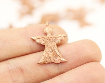 May include: A small, detailed, copper-colored angel charm with a textured surface. The charm is in the shape of an angel with wings outstretched.