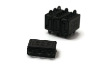 May include: A set of black magnetic clasps for jewellery making. The clasps are small and rectangular with a textured surface.