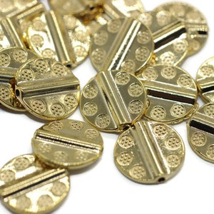 May include: A group of gold-colored metal beads with a decorative pattern. The beads are round and have a hole in the center for stringing.