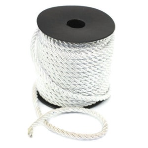 May include: A spool of white braided rope with a black plastic centre. The rope is coiled neatly on the spool and a length of rope is hanging off the side.