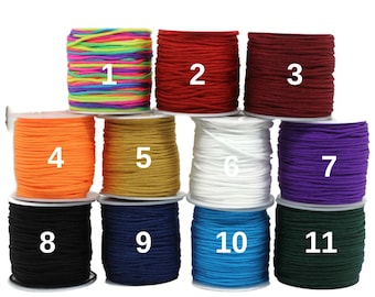 May include: Eleven spools of colourful elastic cord, numbered 1 through 11. The cords are wound around white spools. The cords are in the following colours: rainbow, red, burgundy, orange, gold, white, purple, black, navy blue, turquoise, and forest green.