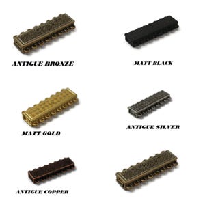 May include: Close-up of six rectangular jewelry clasps in various metallic finishes: antique bronze, matt black, matt gold, antique silver, and antique copper. Each clasp has a decorative pattern and small loops for attaching jewelry. The text on the image reads "ANTIQUE BRONZE", "MATT BLACK", "MATT GOLD", "ANTIQUE SILVER", and "ANTIQUE COPPER".