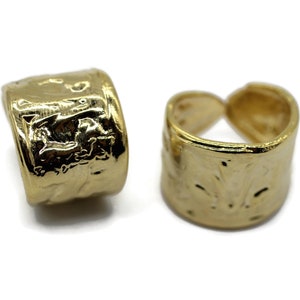 May include: Two gold-toned metal rings with a textured surface. The rings are designed to be used as a charm or pendant.