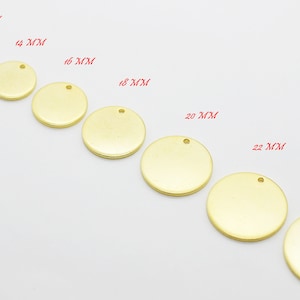 May include: A collection of gold-colored, round metal blanks for jewelry making, ranging in size from 10mm to 25mm. Each disc has a small hole for attaching to chains or other components. The sizes are labeled in red text.