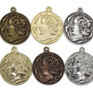 May include: Six antique-style gold, silver, and bronze pendants featuring a profile of a woman's face with flowing hair. Each pendant has a loop at the top for hanging.