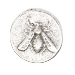 May include: A silver charm in the shape of a bee with detailed wings and a textured body.
