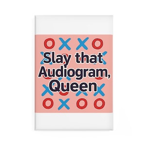 Può includere: Un taccuino rettangolare bianco con sfondo rosa. Presenta il testo "Slay that Audiogram, Queen" in un carattere audace e stilizzato. Il design include cerchi rossi e crocette blu, che ricordano il gioco del tris.