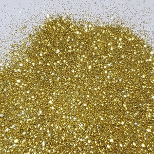 May include: A close-up of a pile of fine gold glitter. The glitter is very sparkly and reflects light.