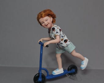May include: A miniature figurine of a child with reddish-brown hair riding a blue kick scooter. The figure wears a white short-sleeved shirt with a colorful dinosaur pattern, light green checkered shorts, and white sneakers with light blue accents.