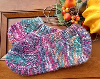 Puede incluir: Un par de calcetines de punto coloridos con un patrón de rayas multicolores en tonos de rosa, morado, azul, verde y blanco.